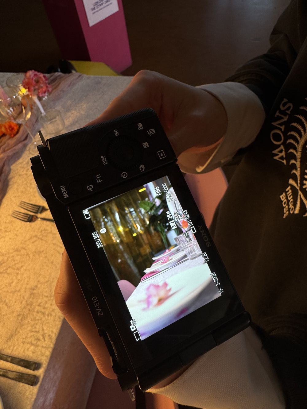 Camera in de hand die de gedekte tafel vastlegt tijdens een event