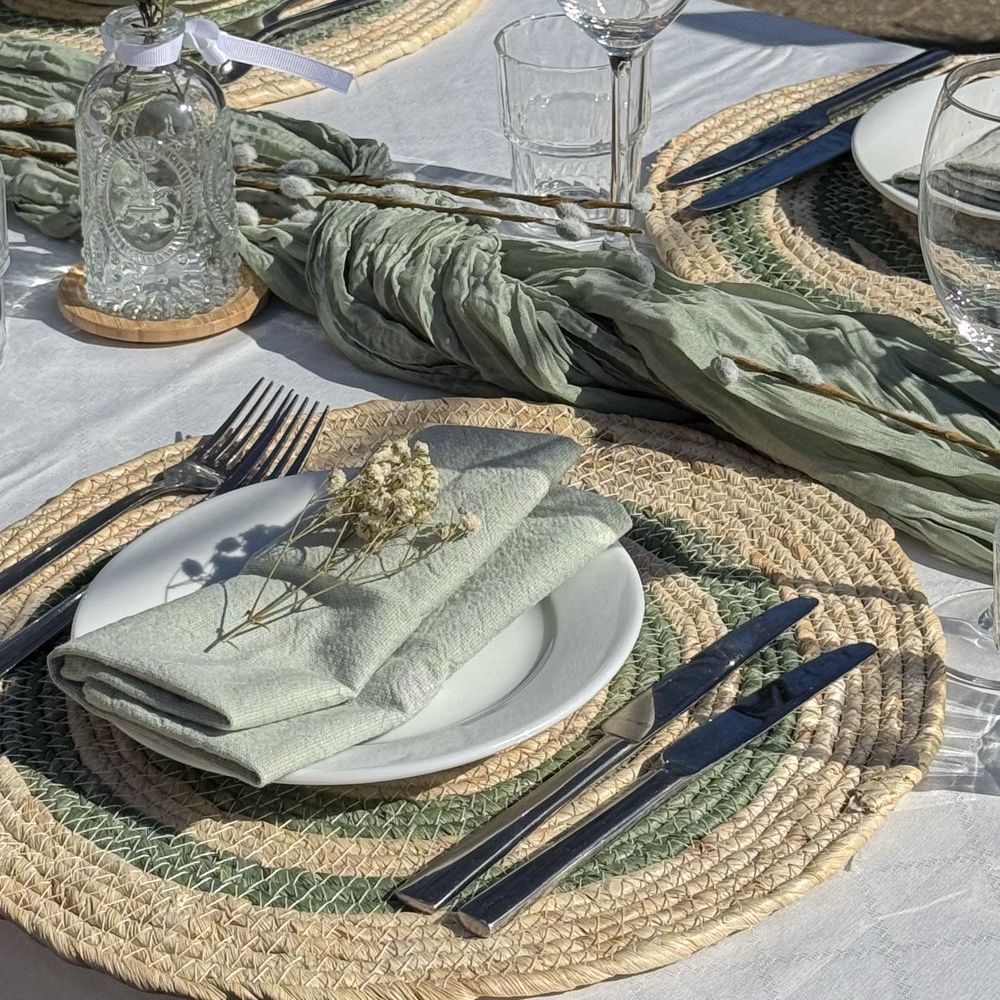 Couvert met groen servet, rieten placemat en gedroogde bloemen